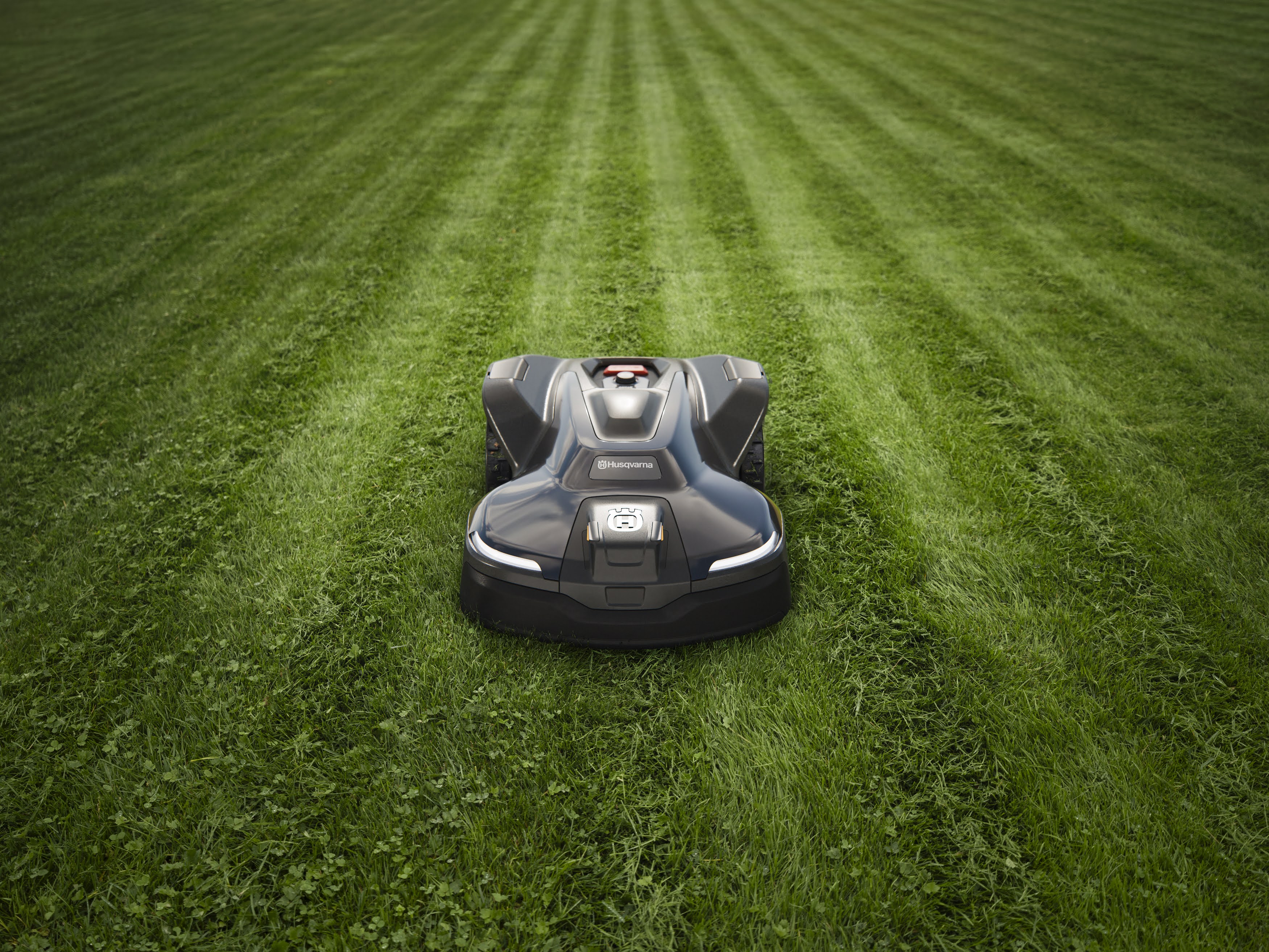 Husqvarna Automower cutting clean stripes into a lawn