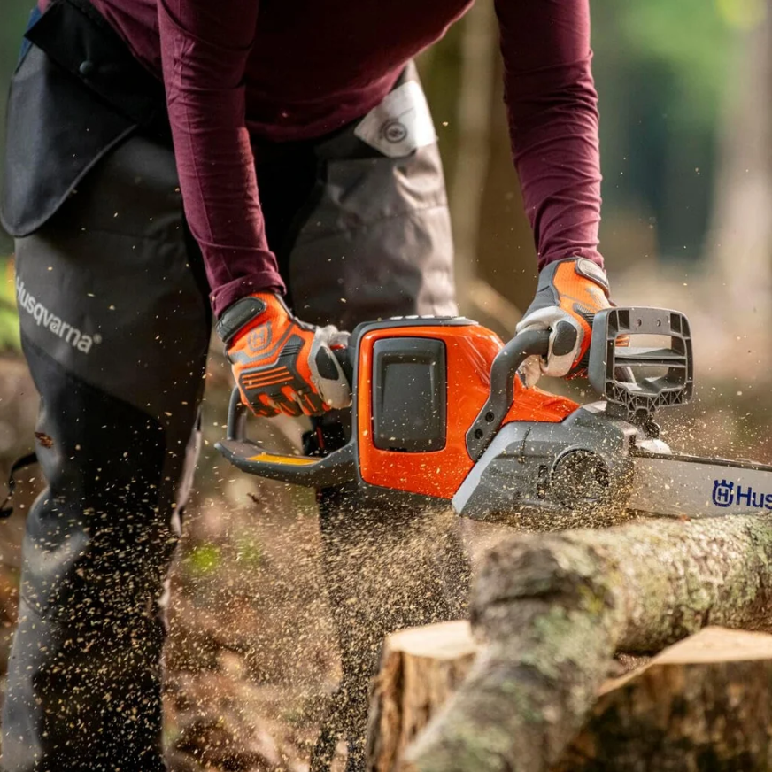 Husqvarna battery powered chainsaw cutting through a log