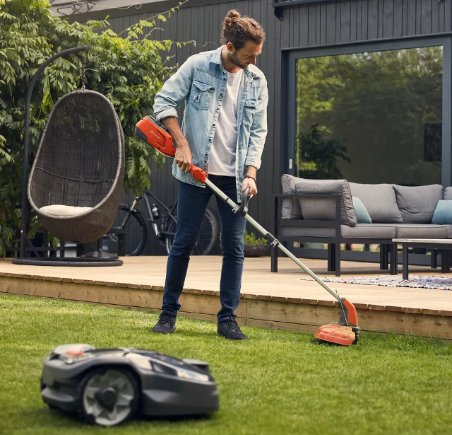Husqvarna battery powered string trimmer in a backyard